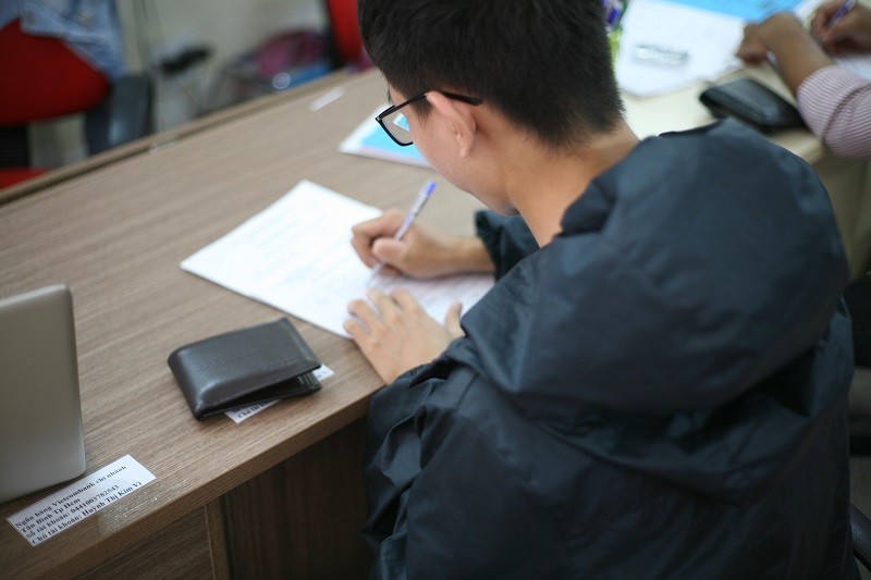 Customers fill out the registration form at Dong Tam